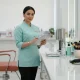 مدیر سالن در حال بررسی چک لیست خرید تجهیزات سالن زیبایی کنار ابزارهای ضروری و ایستگاه ضدعفونی