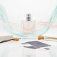 تصویر مفهومی از ترندهای عطر و تغییرات بازار رایحه با بطری عطر بدون برند و عناصر رایحه‌ای مثل صابون، وانیل و چوب در نور روشن